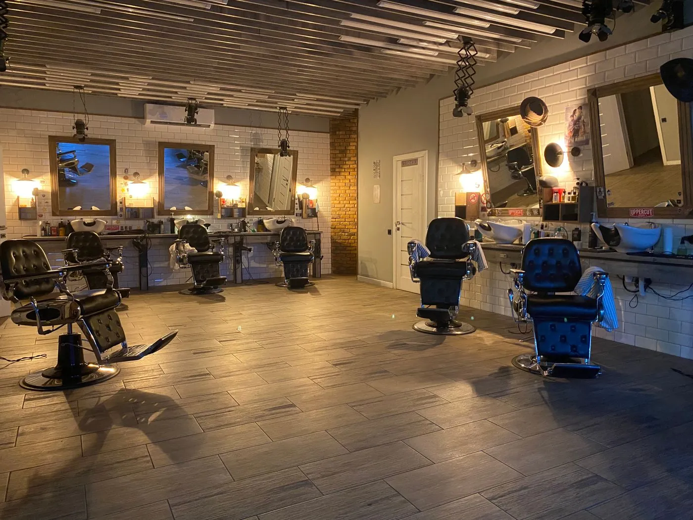 A dimly lit barbershop with dark wood and brass fittings