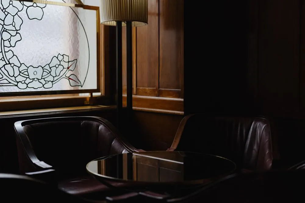 Dark leather barber chairs in a wood-panelled room